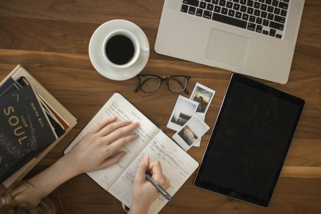 A person writing in a journal at a desk