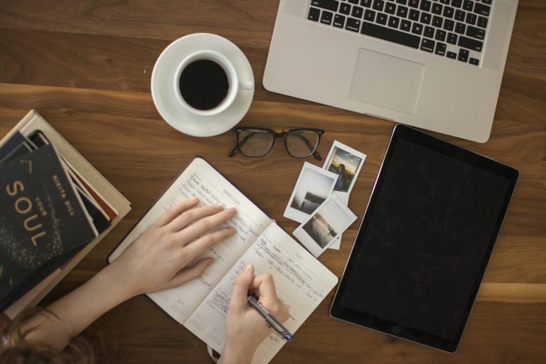 A person writing in a journal at a desk